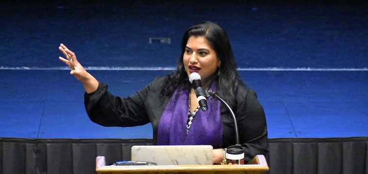 A woman giving a speech at a podium.